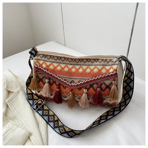 Detail of bohemian woven bag with geometric patterns and colorful tassel charms