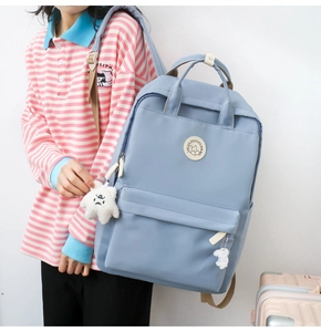 Detail of light blue school backpack with side view showing soft straps and plush charm