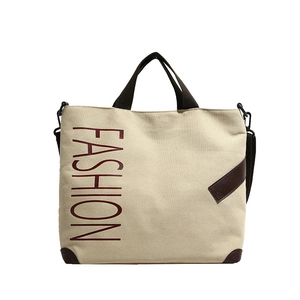 Large beige canvas tote bag with brown straps and vertical red fashion print