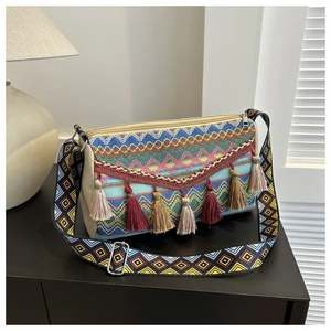 Close-up of bohemian woven tote bag featuring colorful tassels and ethnic diamond patterns