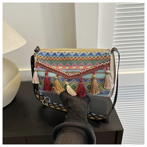 Close-up of bohemian bucket bag featuring colorful woven patterns and long fringe tassels