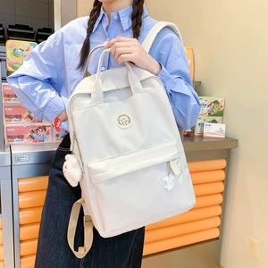 Minimalist white large capacity backpack for women featuring a plush ball pendant accessory