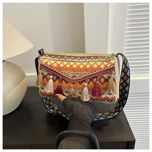 Detail of bohemian woven bag featuring colorful patterns and long decorative tassels