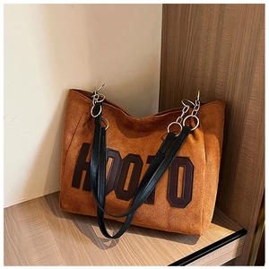 Detailed close-up of large brown faux suede tote bag with HOOZO letter patch and leather straps