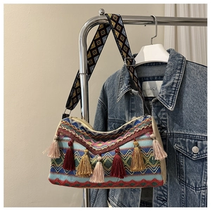 Detailed macro view of bohemian woven bag with colorful geometric patterns and decorative tassels