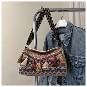 Detail of bohemian woven texture and colorful tassel charms on a stylish crossbody bag
