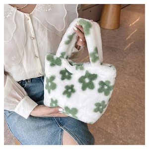 Close-up of white plush tote bag with green flower pattern and soft faux fur texture