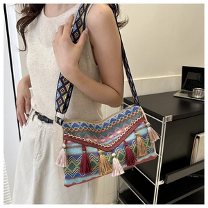Close-up of bohemian tassel cross-body bag featuring colorful geometric embroidery details