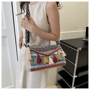 Close-up of bohemian shoulder bag with colorful tassels and geometric woven patterns