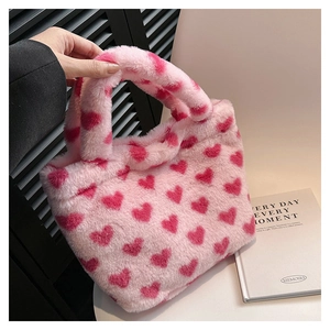 Detailed texture of pink plush tote bag with red heart patterns and soft faux fur handle