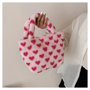 Close-up of pink plush handbag with red heart patterns and soft faux fur texture