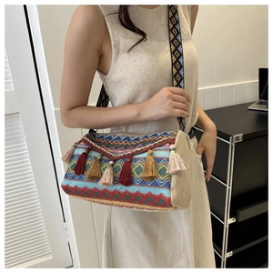 Detail of bohemian shoulder bag with colorful tassels and ethnic geometric wide strap
