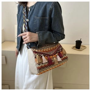 Detail of bohemian crossbody bag showing colorful tassels and geometric jacquard fabric