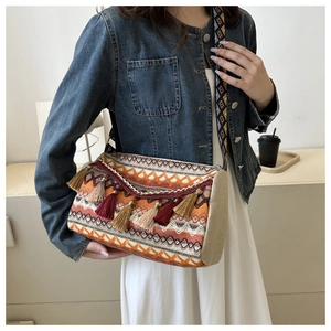 Close-up of woven ethnic shoulder bag with vibrant wave patterns and colorful tassels