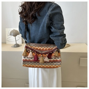 Close-up of bohemian woven crossbody bag with colorful tassels and ethnic geometric pattern
