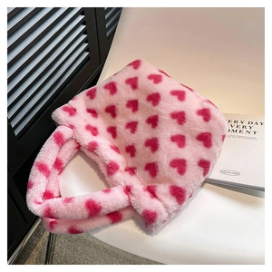 Detail of soft pink plush tote bag with red heart pattern on a minimalist chair