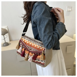 Detail of bohemian ethnic tote bag featuring geometric embroidery and tassel fringe decor