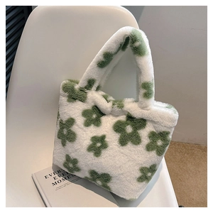 Detailed texture of white plush tote bag with green floral patterns on a white chair