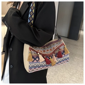 Close-up of Bohemian bag with ethnic embroidery patterns and colorful tassels
