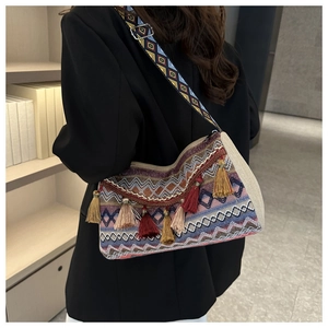 Detail of bohemian woven bag with colorful geometric patterns and decorative tassels