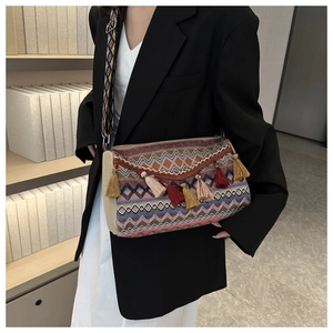 Close-up of ethnic woven crossbody bag with colorful tassels and geometric patterns