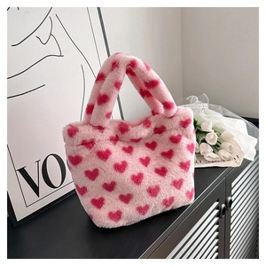 Close-up of pink plush handbag with red heart patterns and fluffy texture detail