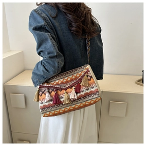 Detailed macro view of woven ethnic shoulder bag with vibrant tassels and geometric patterns