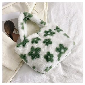 Close-up of white plush handbag featuring green floral pattern with soft faux fur texture