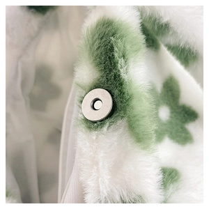 Close-up of white plush bag featuring green floral patterns and silver magnetic clasp