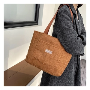 Detail of plush teddy fleece tote bag in caramel brown with white logo patch