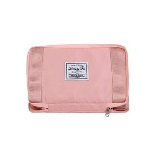 Detailed macro view of a pink waterproof nylon travel bag featuring dual zippers and woven straps