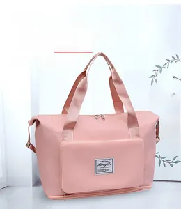 Pink waterproof fitness bag featuring a specialized sleeve for trolley suitcase handles