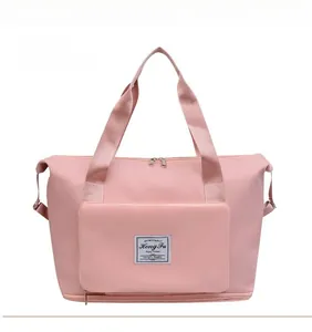 Detail view of pink waterproof nylon travel bag with front pocket and expandable bottom zipper