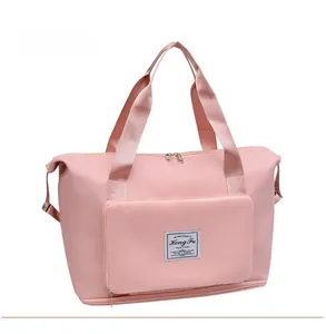 Detailed side view of pink high-capacity travel bag with front zipper pocket and luggage tag
