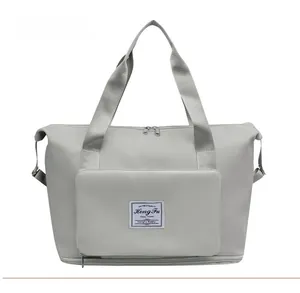 Detailed front view of light grey nylon travel bag with logo pocket and sturdy handles