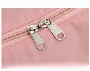 Close-up of pink travel bag showing durable dual metal zippers and fine fabric texture