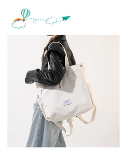 Side view of a large white nylon drawstring backpack showing the side pocket and straps