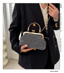 Detail view of sparkly rhinestone evening handbag with gold handle and vintage clasp