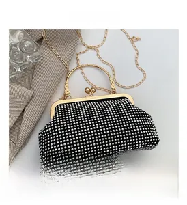 Detail of black evening clutch with silver rhinestones and gold clasp lock handle
