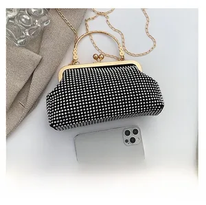 Size comparison of black rhinestone handbag with smartphone showing its compact dimensions