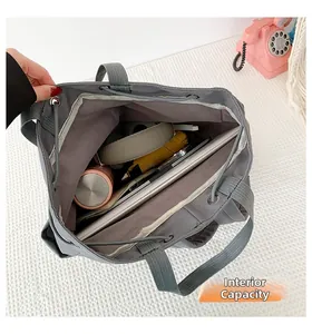 Large capacity view of grey nylon bag showing interior with tablet, headphones and bottle