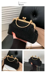 Detail of black rhinestone evening clutch bag with gold metal handle and chain strap