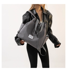 Detailed close-up of charcoal grey nylon backpack showing fashion leisure woven label