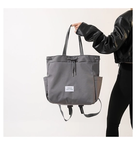 Detail of grey nylon drawstring backpack bag with adjustable straps and side pocket