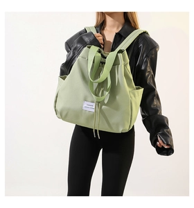 Detailed view of the light green nylon drawstring bag with adjustable shoulder straps