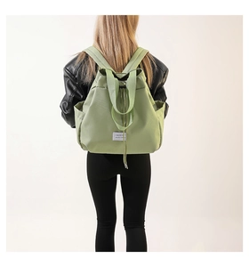 Close-up of lightweight green nylon fabric and drawstring closure on fashion backpack