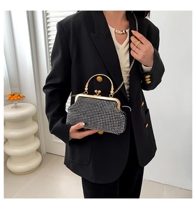 Detail of elegant black evening clutch with silver rhinestones and gold metal handle