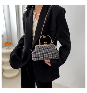 Detail of a sparkling black rhinestone handbag with golden handles and chain strap
