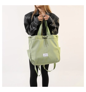 Detail view of light green nylon tote with drawstring closure and side pockets