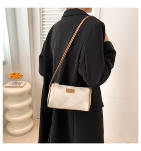 Elegante borsa a tracolla in tela beige con finiture in pelle marrone e tracolla sottile
